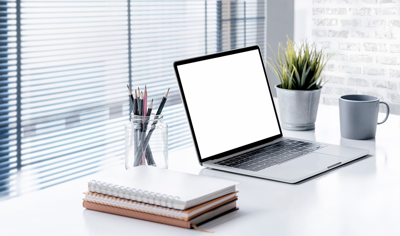 Modern Office Desk with Laptop Computer and Supplies on White Ta